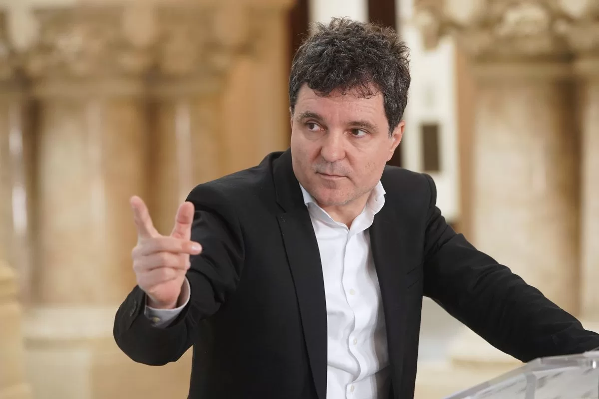 Nicușor Dan arată cu degetul la o conferință de presă