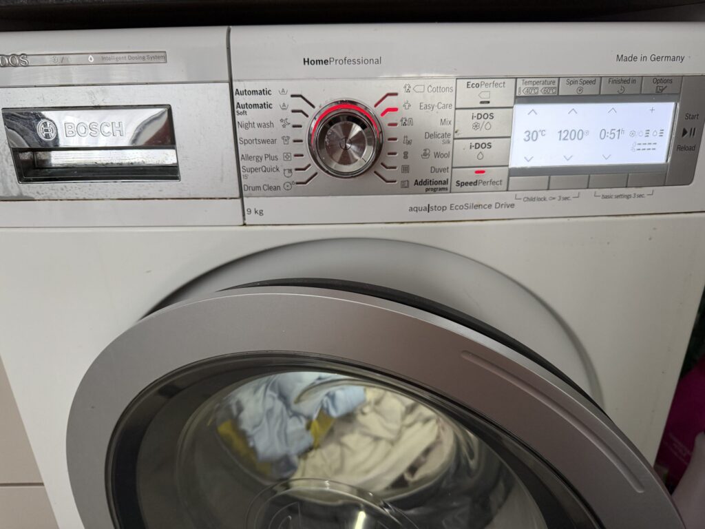 O mașină de splăat care spală împreună rufe albe și colorate